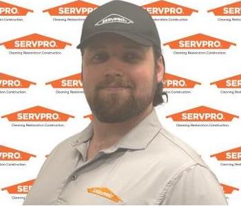 SERVPRO employee in front of a SERVPRO background.